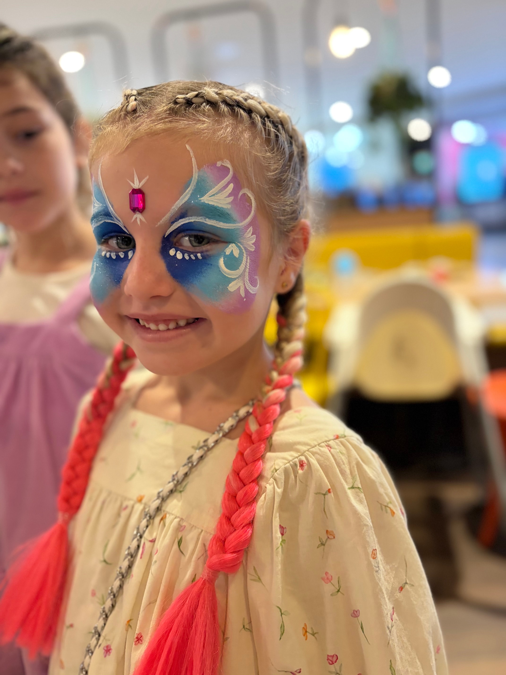 Girl with Frozen Elsa inspired blue and pink face paint with gem