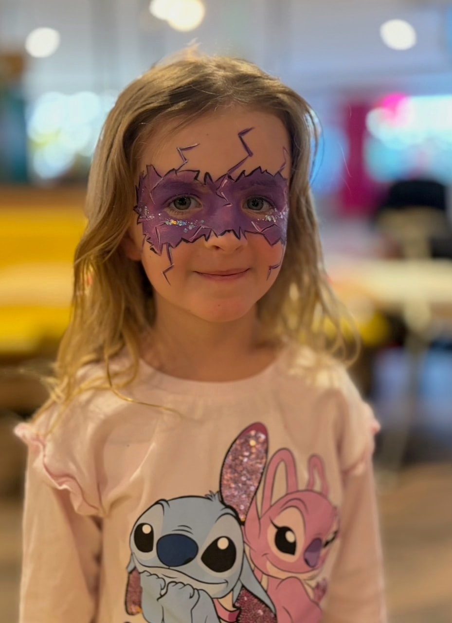 Child with purple lightning mask face paint